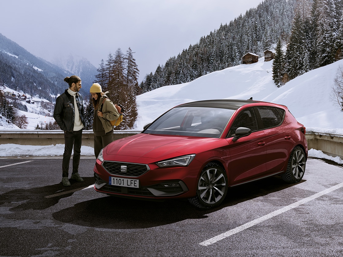 Une voiture seat rouge dans un cadre montagneux enneigé, avec une assurance automobile pour la couverture du véhicule.