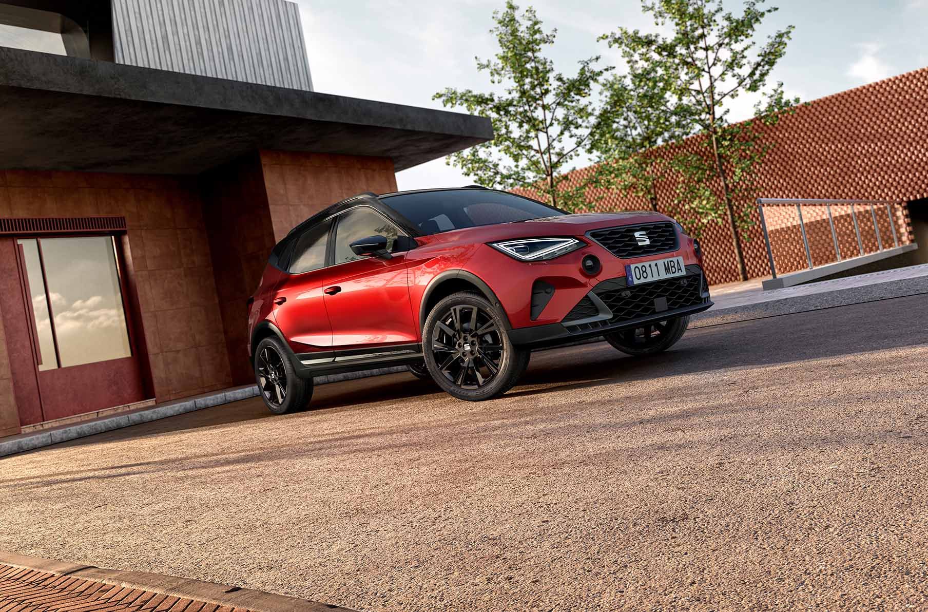 new seat arona black edition en rouge désir, avec des jantes cosmo noires de 18 pouces, des jupes latérales noires, des barres de toit noires et des bouches d'aération grises.